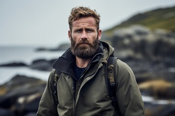 Portrait of a glad man in his 30s dressed in a water-resistant gilet against a rocky shoreline background. AI Generation - obrazy, fototapety, plakaty