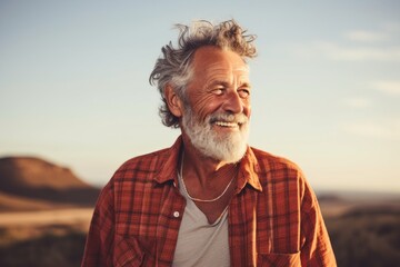 Portrait of a cheerful man in his 80s dressed in a relaxed flannel shirt against a serene dune landscape background. AI Generation - obrazy, fototapety, plakaty