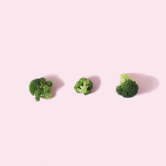 Broccoli with shadow on pink background. Minimal food concept.