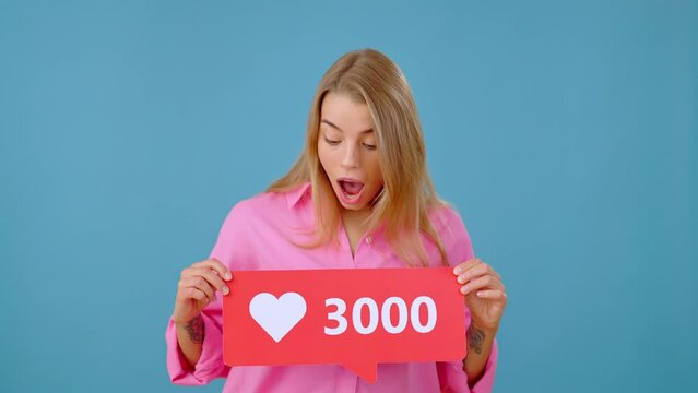 Positive lady exclaims demonstrating red button with likes amount