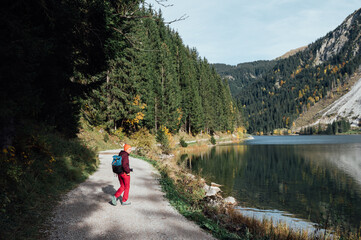 A man walks in nature, near a lake in the mountains.
