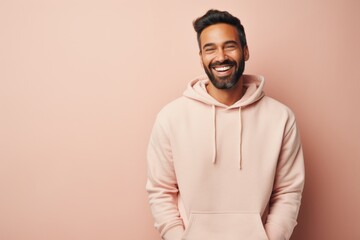 Portrait of a blissful man in his 30s sporting a comfortable hoodie against a pastel or soft colors background. AI Generation