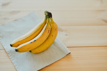 Close-up of a bunch of bananas on a wooden kitchen table background