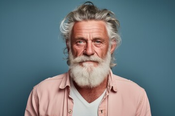 Portrait of a glad man in his 70s wearing a rugged jean vest against a pastel or soft colors...