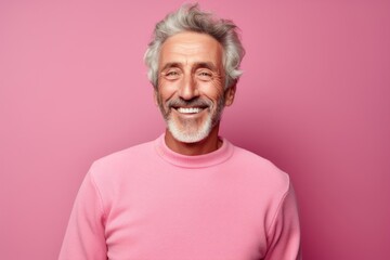 Portrait of a happy man in his 70s wearing a thermal fleece pullover against a pastel or soft...