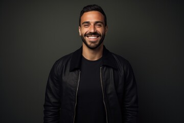 Obraz premium Portrait of a happy man in his 30s wearing a trendy bomber jacket against a minimalist or empty room background. AI Generation
