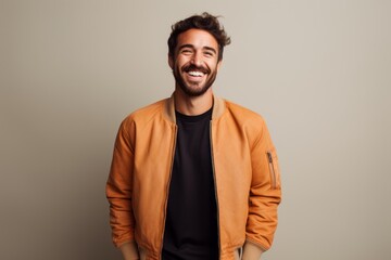 Portrait of a happy man in his 30s wearing a trendy bomber jacket against a minimalist or empty room background. AI Generation