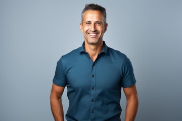 Fototapeta premium Portrait of a happy man in his 40s wearing a sporty polo shirt against a minimalist or empty room background. AI Generation
