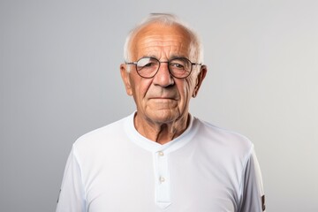Obraz premium Portrait of a jovial man in his 80s sporting a breathable mesh jersey against a minimalist or empty room background. AI Generation
