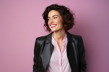 Portrait of a grinning woman in her 30s sporting a stylish leather blazer against a solid pastel...
