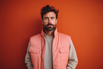 Fototapeta premium Portrait of a content man in his 30s dressed in a water-resistant gilet against a solid pastel color wall. AI Generation