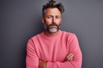 Obraz premium Portrait of a content man in his 40s dressed in a warm wool sweater against a solid pastel color wall. AI Generation