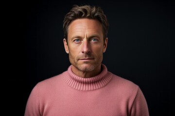 Fototapeta premium Portrait of a tender man in his 40s dressed in a warm wool sweater against a solid pastel color wall. AI Generation
