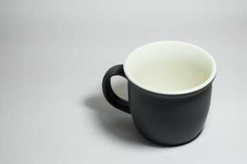 An empty dark grey real mug isolated on white background with clear and natural texture for background. Artistic shading of porcelain or ceramic mug.