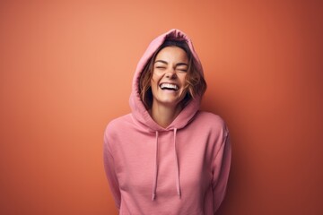 Portrait of a joyful woman in her 30s sporting a comfortable hoodie against a blank studio backdrop. AI Generation