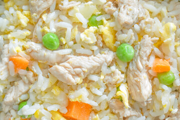 Chicken and egg fried rice with carrot and green peas in a bowl. Healthy food.
