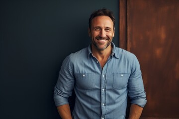 Obraz premium Portrait of a grinning man in his 40s sporting a versatile denim shirt against a light wood minimalistic setup. AI Generation