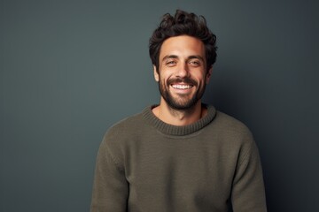 Obraz premium Portrait of a cheerful man in his 30s dressed in a warm wool sweater against a bare monochromatic room. AI Generation