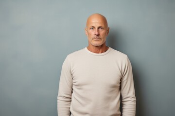 Portrait of a glad man in his 50s sporting a long-sleeved thermal undershirt against a plain cyclorama studio wall. AI Generation - obrazy, fototapety, plakaty