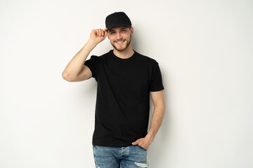 Portrait of happy casual man smiling, guy wearing black t-shirt an d cap at white wall, Isolated on...