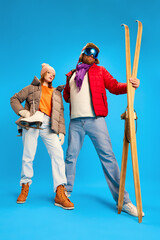 Funny portrait of father and daughter dressed winter outfit, warm suit and goggles mask and holds...