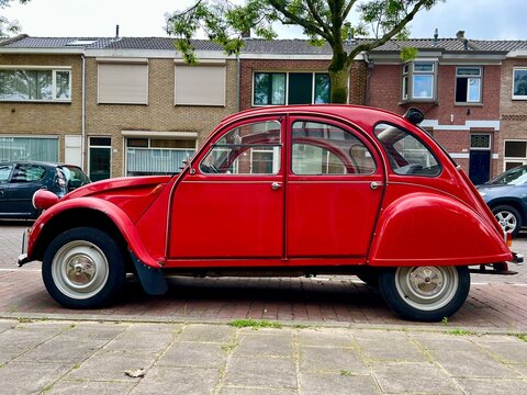 Tilburg, Netherlands - 09.09.2023: classic red cabrio car - popular Citroen 2cv - on the street.