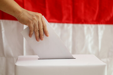 Indonesian election.  hands inserting ballot papers into the ballot box during the Indonesian...