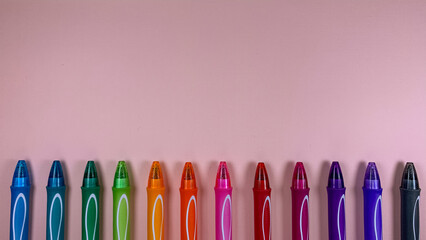set of multi-colored gel pens on a pink background