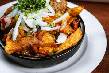 Beef stew with potatoes, carrots and herbs on black background with copy