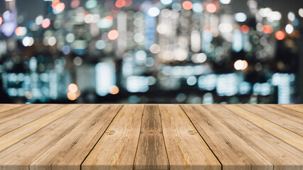 Realistic wooden board empty table in front of blurred background. Night lights bokeh on blur restaurant background.