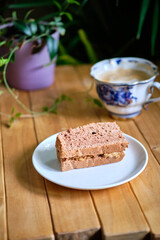 Pieces of chocolate  sponge cake lie in a blue plate. Side view.
