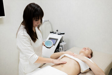 RF body cavitation lifting procedure in a beauty salon. Ultrasound therapy to reduce fat and elasticity of the skin