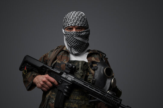 Militant from the Middle East, dressed in a white keffiyeh and camouflaged field attire, wielding an automatic rifle, set against a neutral gray backdrop