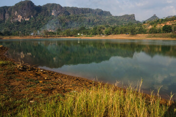 view of the clear lake water and yellow grass on the edge