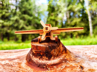 Vintage toy wooden airplane in nature. Private adventure traveling by flight. Aircraft for nature protection, eco friendly, fire extinguishing, rescue of victims. Plane crash, breakdown