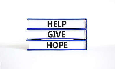 Help give hope symbol. Concept word Help give hope on beautiful books. Beautiful white table white background. Business motivational help give hope concept. Copy space.