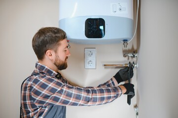 Professional engineer installing a natural gas boiler at home, he is checking the pipes