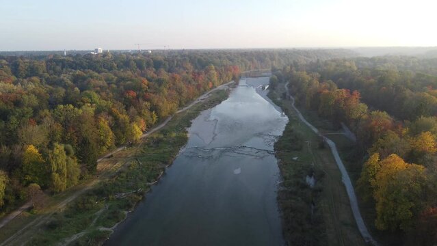 Drone image of isar river flowing into Munich, in beautiful autumn time with colorful trees seen from above