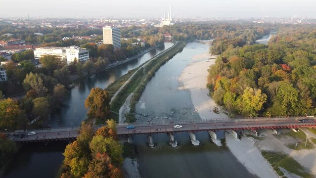 Drone image of isar river flowing into Munich, in beautiful autumn time with colorful trees seen from above