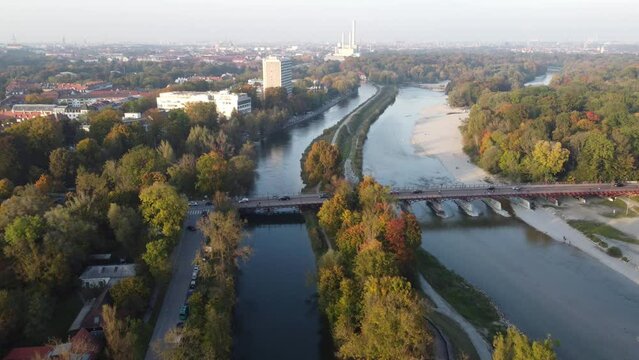Drone image of isar river flowing into Munich, in beautiful autumn time with colorful trees seen from above