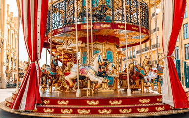 Old French carousel in a holiday park. Three horses and airplane on a traditional fairground vintage carousel. Merry-go-round with horses 