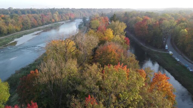 Aerial views of autumn in Munich. Isar river seen from above with colorful trees nearby
