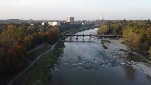 Drone image of isar river flowing into Munich, in beautiful autumn time with colorful trees seen from above