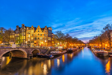 Fototapeta premium Amsterdam Netherlands, night city skyline at canal waterfront