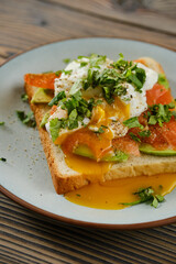 Fototapeta na wymiar Closeup view of sandwich with trout, avocado and poached egg