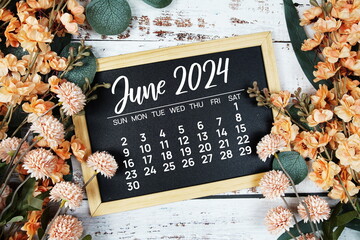 June 2024 monthly calendar with flower bouquet decoration  on wooden background