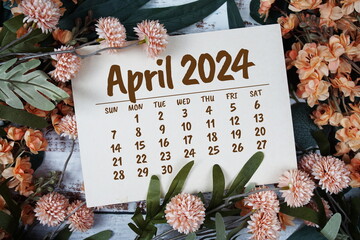 April 2024 monthly calendar with flower bouquet decoration  on wooden background