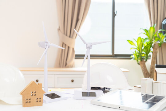 Architect team planning design apply renewable or solar energy on architectural building  with virtual reality technology hologram. Alternative green energy in future concept.