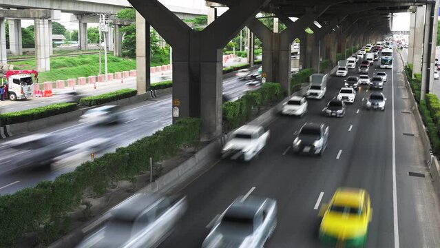 Timelapse of many cars and buses driving by the multiline asphalt road under the junction bridge in the city. Transport infrastructure of the metropolis for many cars and trucks