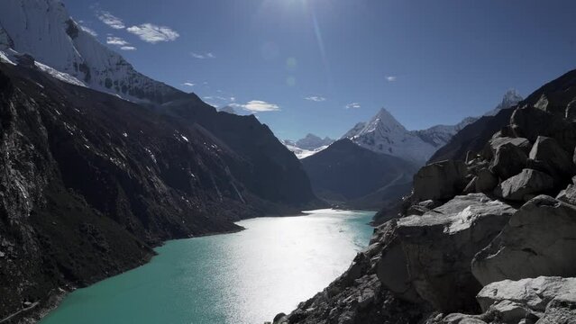 beautiful turquoise water of the lake at laguna paron lagoon in the high andes mountains of the cordillera blanca at huascaran, Peru, with snow covered mountain peaks on a bright sunny day.